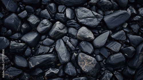 a close-up texture of various dark stones with different shapes and subtle color variations, suitable for natural backgrounds and design elements