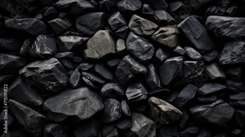 a high-resolution image displaying a variety of black stones with different textures and shapes, creating a natural, monochromatic background photo