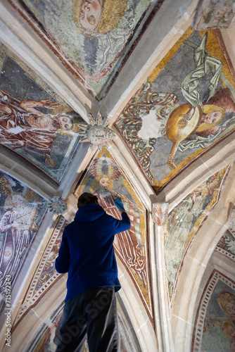 Mature Woman Restorer Retouching Antique Gothic Fresco Under Church Ceiling