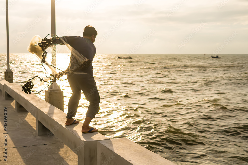 CHONBURI, THAILAND - October, 15, 2023: Unidentified name fisher man use fishing net fishing in the sea at sunset time. CHONBURI, THAILAND - October, 15, 2023: Unidentified name fisher man use fishing net fishing in the sea at sunset time.