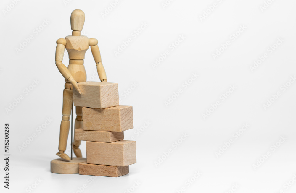 Wooden doll with wooden toy block isolated on white background. business or creative concept Wooden doll with wooden toy block isolated on white background. business or creative concept