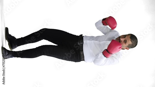 man in full growth. isolated on a white background in business clothes with boxing gloves photo