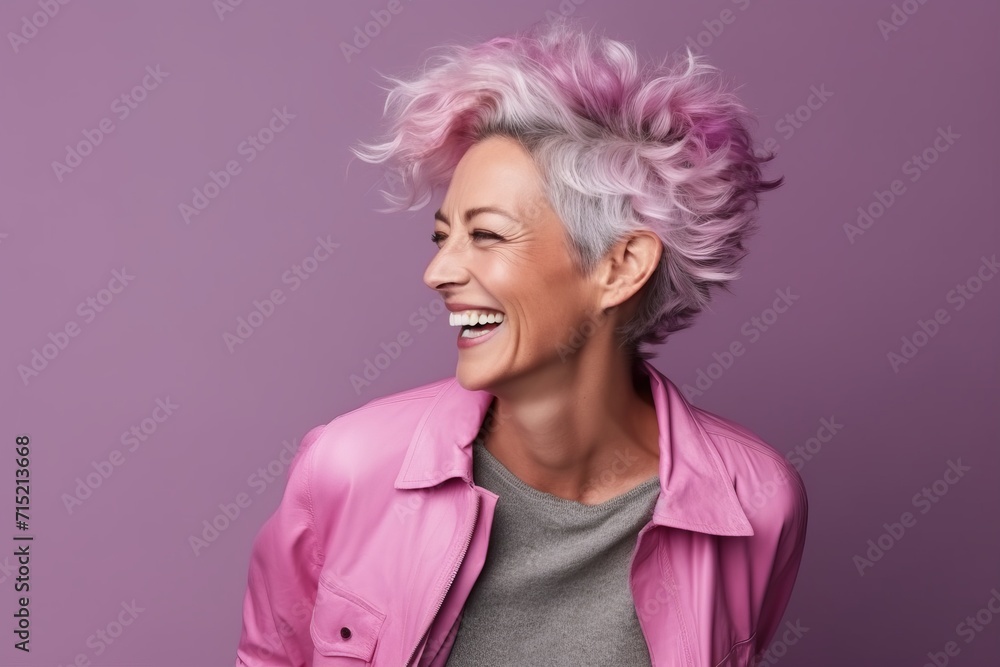Portrait of a happy senior woman with pink hair over purple background