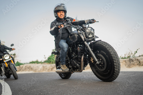 asian motorcylist on jacket and helmet traveling with slow speed