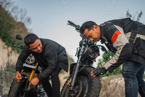 indonesian motorcyclist checking or inspecting wheel before traveling