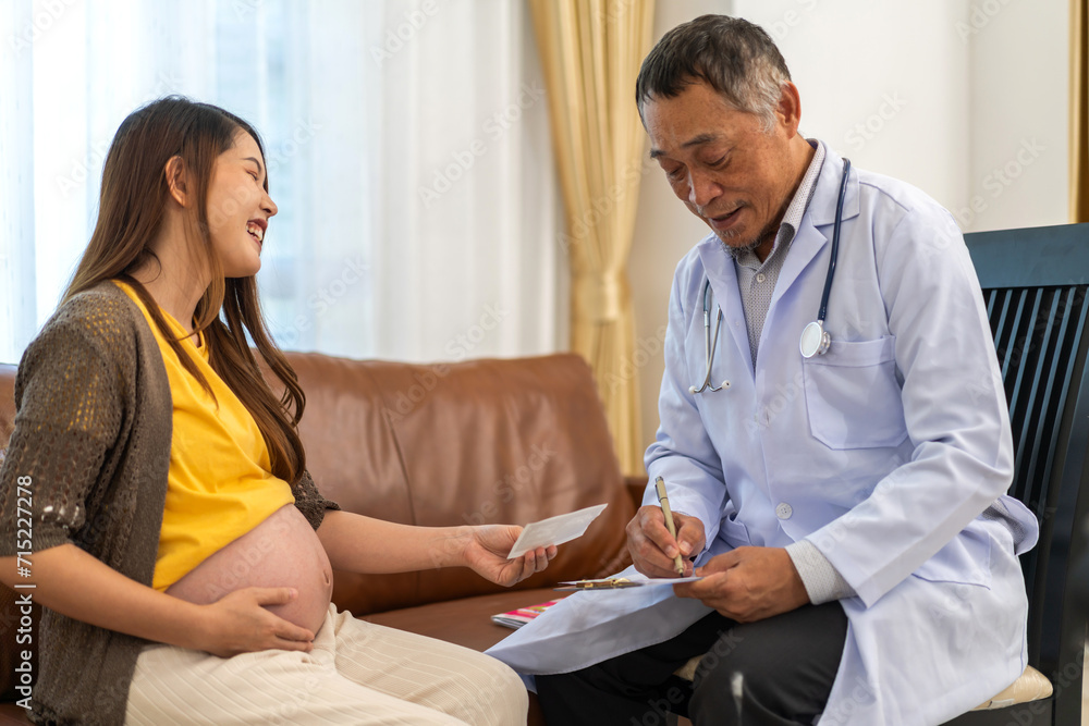 Senior asian man doctor support discussing and consulting care talk to mother woman checkup pregnancy baby in belly, woman pregnant, birth, maternity, ultrasound, healthcare and medicine in hospital Senior asian man doctor support discussing and consulting care talk to mother woman checkup pregnancy baby in belly, woman pregnant, birth, maternity, ultrasound, healthcare and medicine in hospital