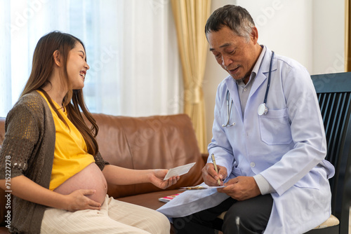 Senior asian man doctor support discussing and consulting care talk to mother woman checkup pregnancy baby in belly, woman pregnant, birth, maternity, ultrasound, healthcare and medicine in hospital