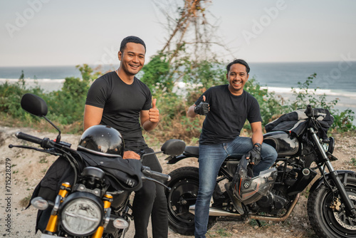 asian men rider sitting on motorbike with thumb up gesture
