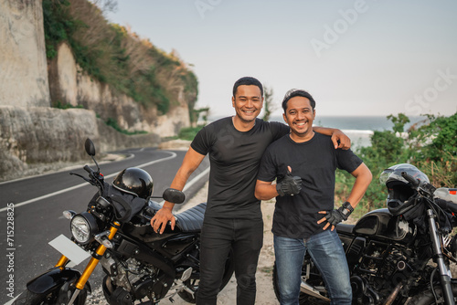 asian rider hugging friend while touring together in countryside © Odua Images