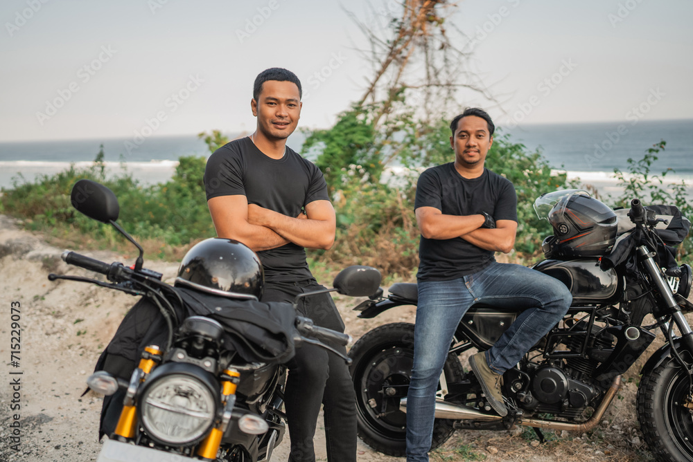 asian men sitting on motorbike with crossed arms