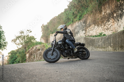 Fototapeta Naklejka Na Ścianę i Meble -  asian rider riding motorcycle on highway road side view