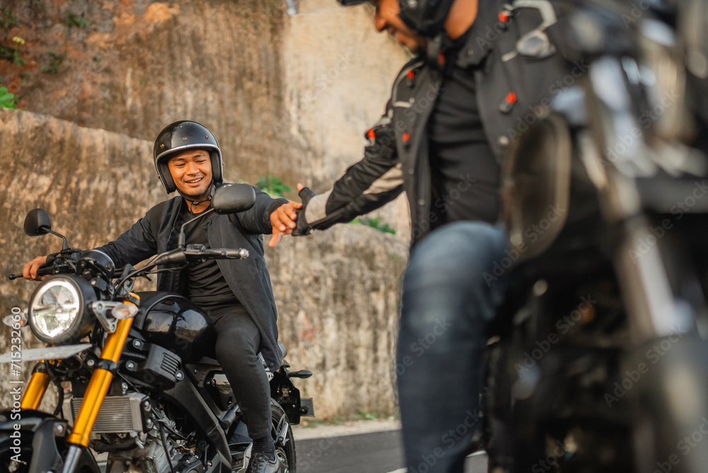 indonesian man riding motorbike with hand shake gesture indonesian man riding motorbike with hand shake gesture