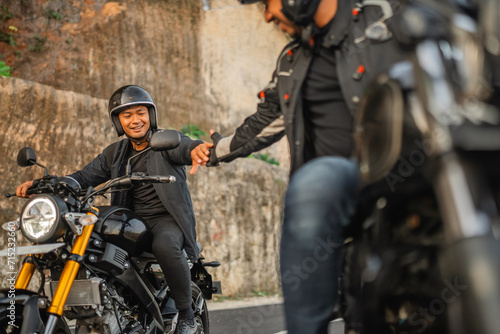 indonesian man riding motorbike with hand shake gesture