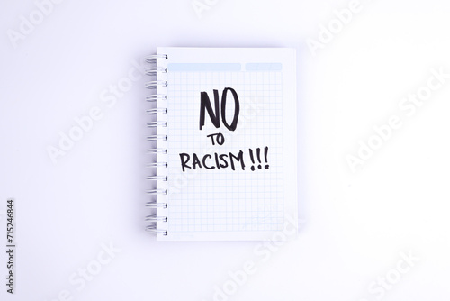 photograph of notebook with phrase "no to racism" on a white background.
