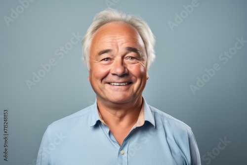Portrait of happy senior man with grey hair. Isolated on grey background.