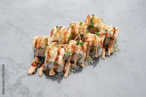 Japanese aburi maki roll with sauce on marble background photo