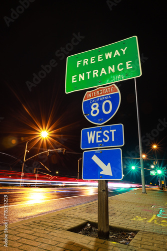 light trails on street with sign for freeway