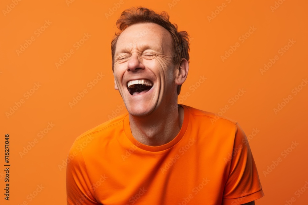 Portrait of a young man in an orange t-shirt on an orange background Portrait of a young man in an orange t-shirt on an orange background