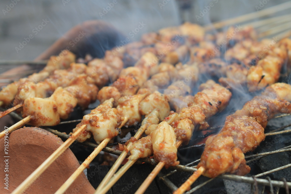 The process of grilling chicken satay on a traditional stove