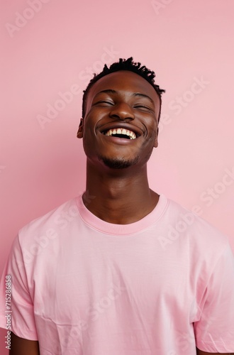 a man smiling in a pink t-shirt on a pink background