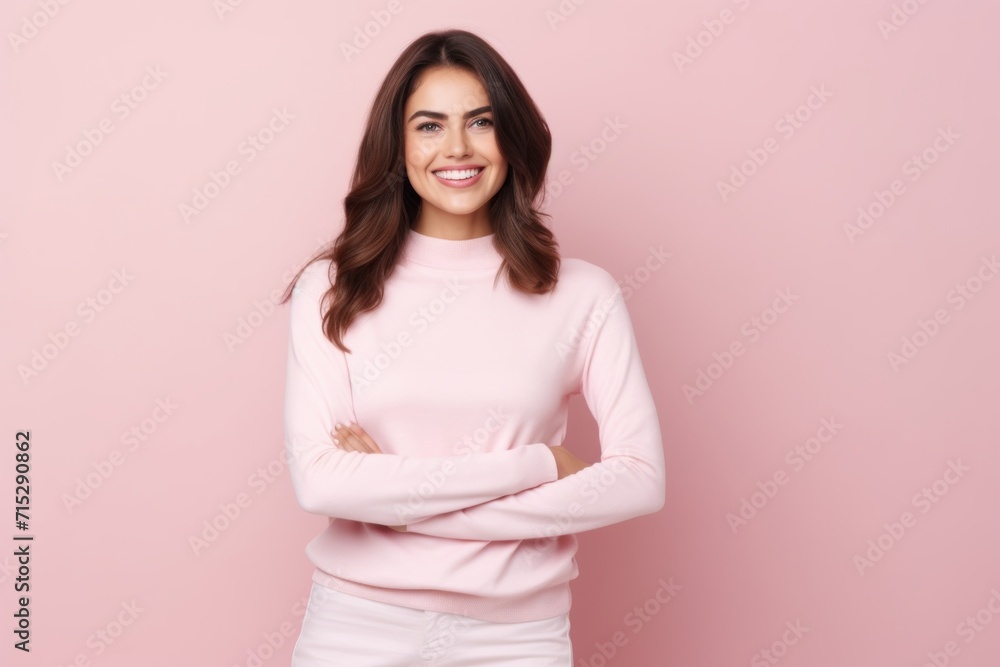 Portrait of a beautiful young woman standing with arms folded over pink background Portrait of a beautiful young woman standing with arms folded over pink background