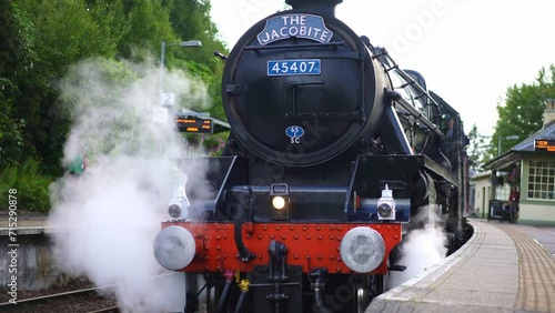 Jacobite train, steam locomotive for tourist, coming from Glenfinnan viaduct bridge in Scotland. Jacobite Railway scenic tourism attraction in Britain. 