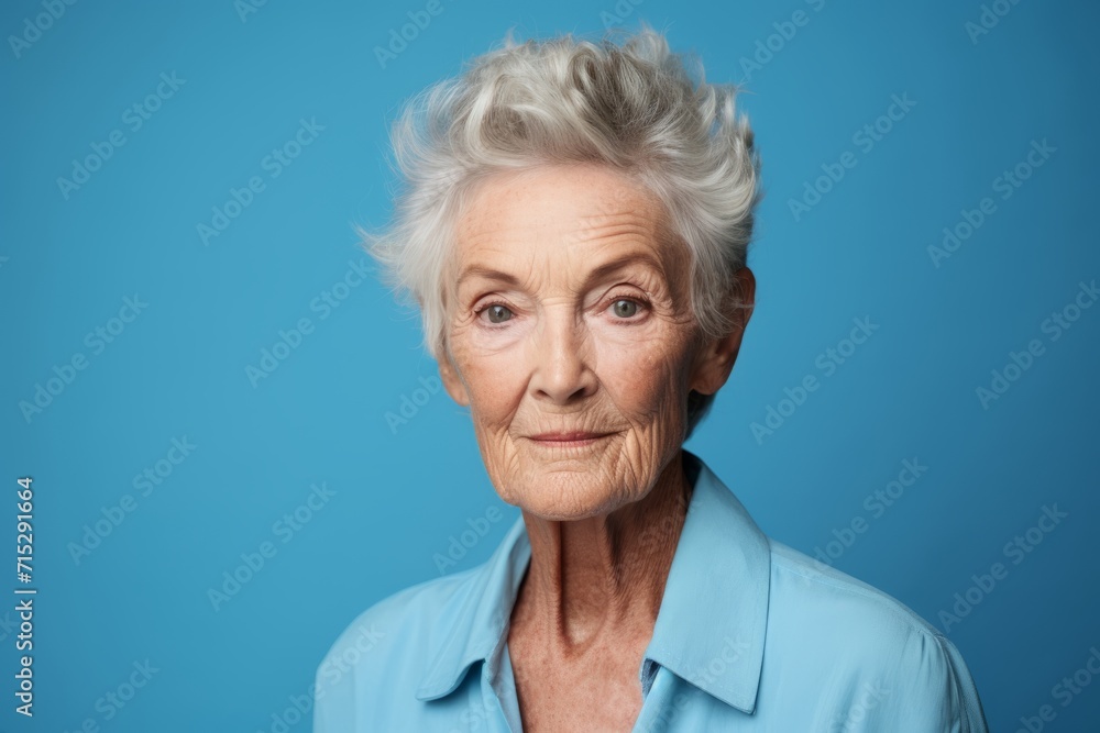 Portrait of happy senior woman looking at camera isolated on blue background Portrait of happy senior woman looking at camera isolated on blue background