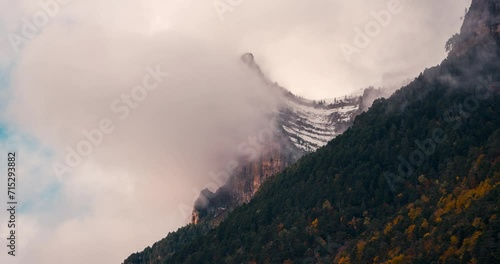 Ordesa national park valley tozal de mallo mountain on a cloudy and misty winter morning timelapse of clouds rolling over mountain peaks in fall autumn season photo