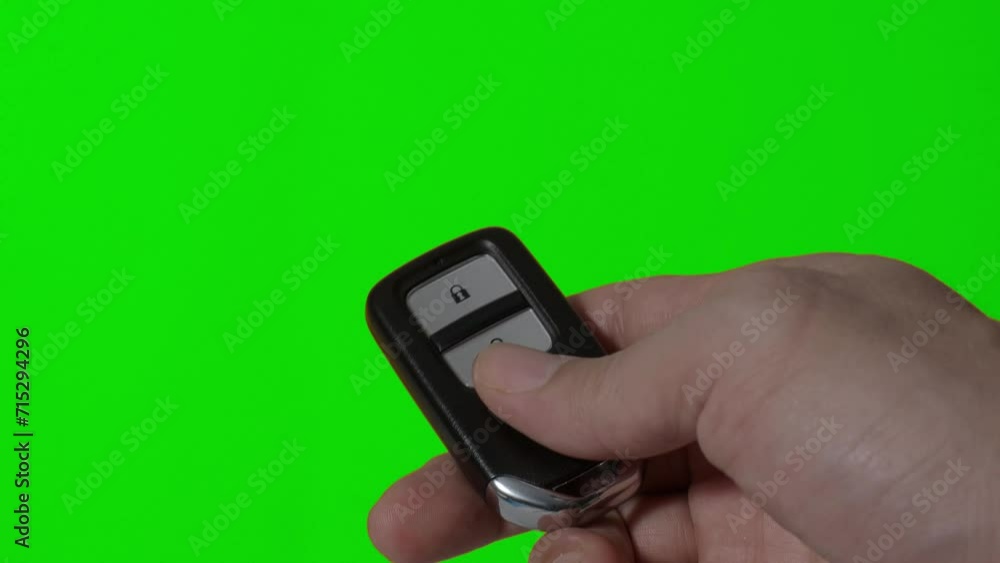 Hand of man holding and pressing car key remote. Hand holds car keys on a clear screen background. Copy space. Concept car rental driving transport automotive. Thumb pressing button of car remote key Hand of man holding and pressing car key remote. Hand holds car keys on a clear screen background. Copy space. Concept car rental driving transport automotive. Thumb pressing button of car remote key