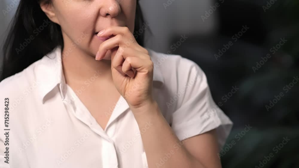 Female nervously biting her fingernails, showcasing a sign of stress or anxiety. Ideal for articles on coping mechanisms and behavioral therapy.