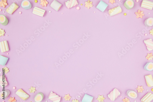Cute pastel purple kawaii background with frame of sweet meringue and marshmallows . Flat lay, top view, copy space. Beautiful childlike design template