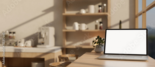 A laptop mockup on a dining table against the window in a modern kitchen or office break room.