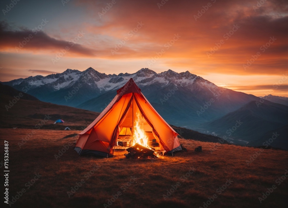 tent with a fire against the backdrop of mountains and sunset
