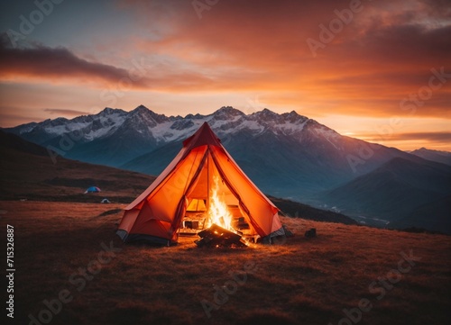 tent with a fire against the backdrop of mountains and sunset 