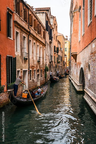 People enjoying gondola ride in a canal in venice photo
