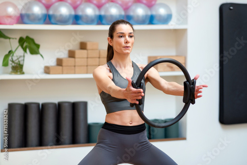 Sportswoman exercising with magic circle in gym