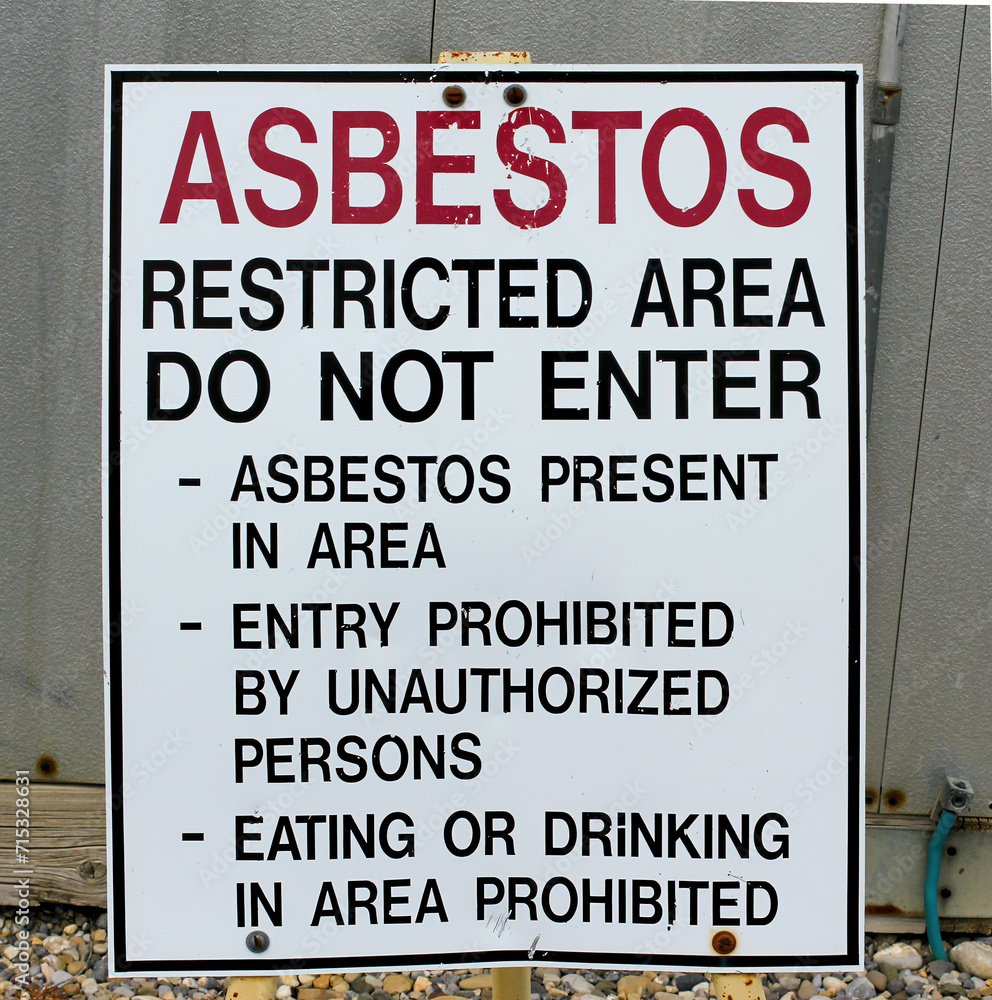 A warning sign at a gas industrial facility with the message: Asbestos restricted area, do not enter. A warning sign at a gas industrial facility with the message: Asbestos restricted area, do not enter.