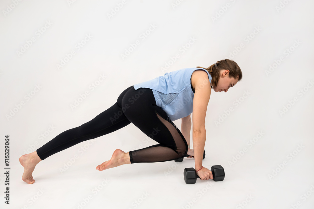 Obraz premium Slim young fitness woman doing exercises with dumbbells at biceps isolated on white