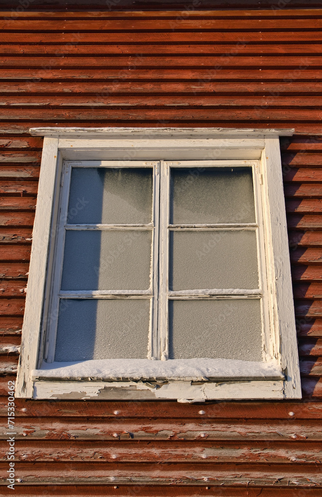 Old wooden building window with frozen glass