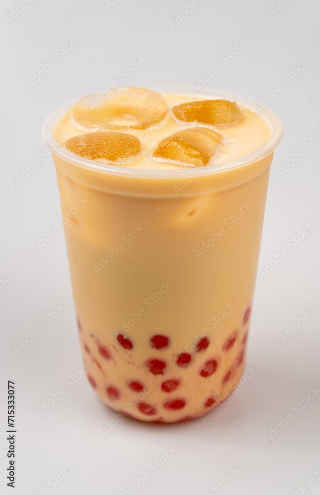 Closeup of a cup of delicious cold yellow bubble tea with red boba Closeup of a cup of delicious cold yellow bubble tea with red boba