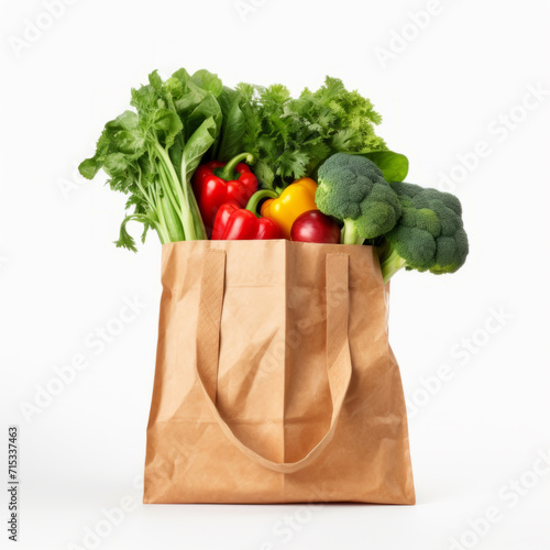 Studio shot of fresh fruits and vegetables in a paper bag on white background