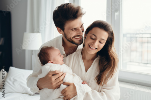 New parents with baby at home, smiling
