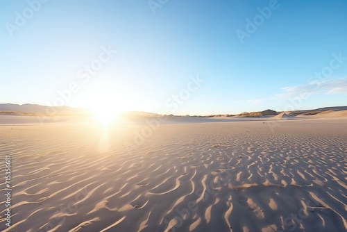 sunrise casting shadows on sand dunes