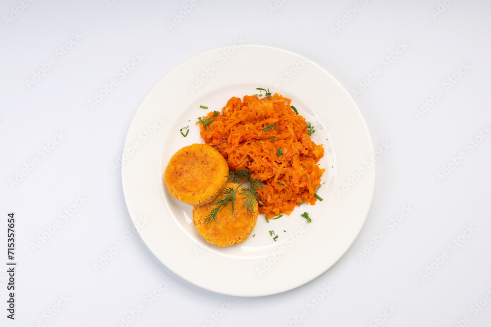 Vegetarian Lunch. Carrot cutlets with stewed cabbage on a white plate and a white background Vegetarian Lunch. Carrot cutlets with stewed cabbage on a white plate and a white background