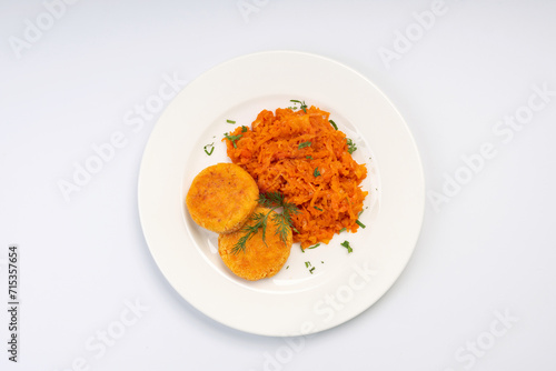 Vegetarian Lunch. Carrot cutlets with stewed cabbage on a white plate and a white background