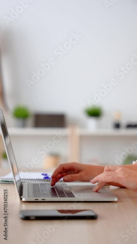 Closeup of unrecognisable woman typing on laptop. Hands using keyboard.