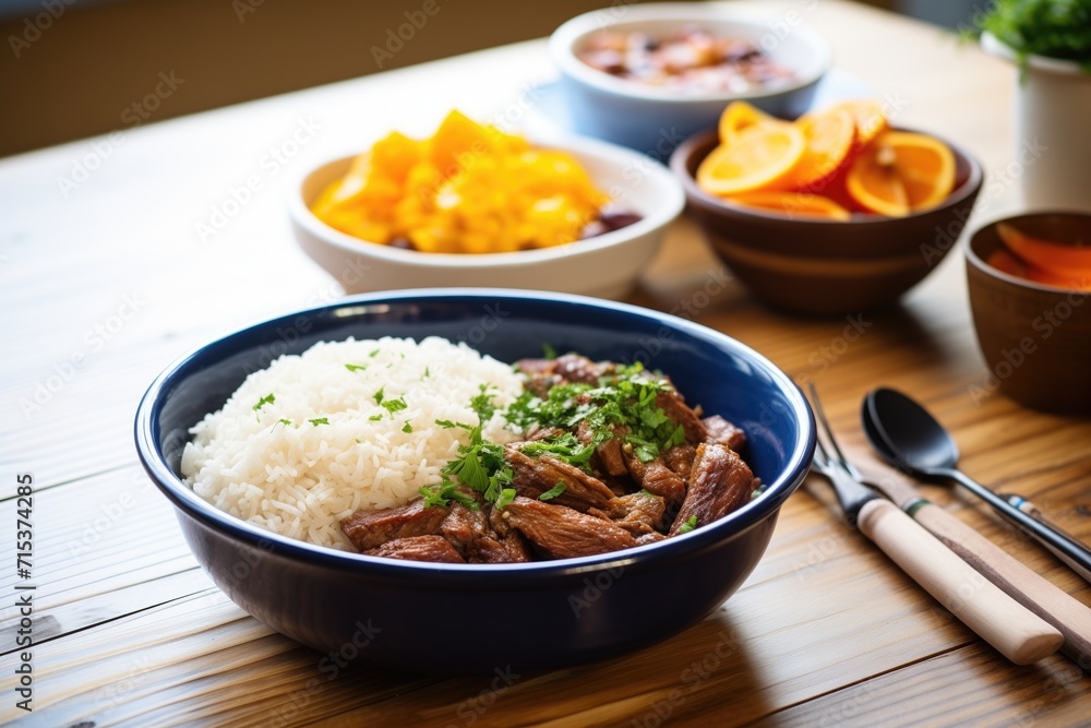 bowl of feijoada with rice and orange slices on a wooden table bowl of feijoada with rice and orange slices on a wooden table