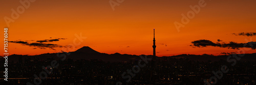 Wide panoramic image of silhouette of Tokyo central area with Mount Fuji and Tokyo skytree at sunset.