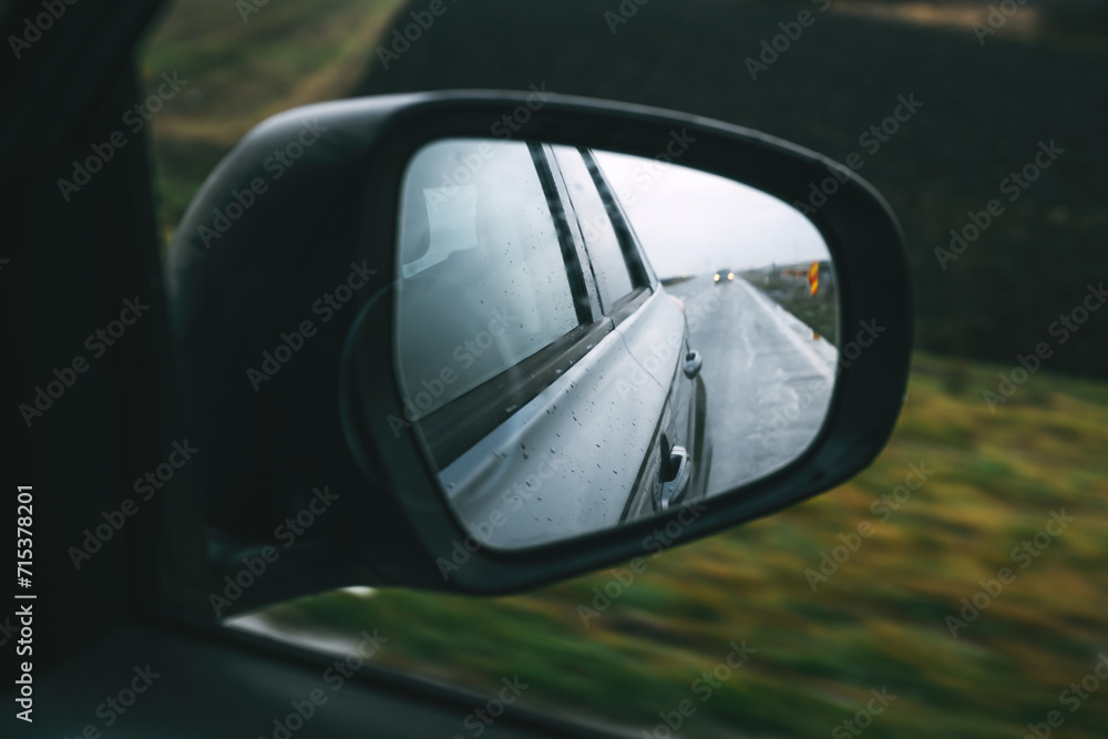 Driving car along the country road in autumn, view at side wing mirror of the vehicle, travel and transport concept