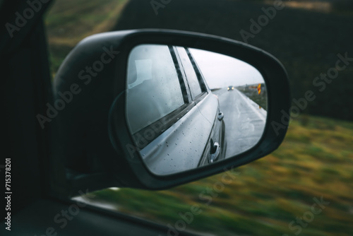 Driving car along the country road in autumn, view at side wing mirror of the vehicle, travel and transport concept